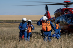 Image of STARS air ambulance crew next to helicopter in a field 
